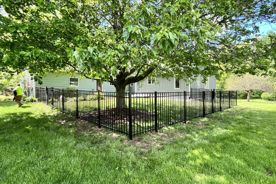 Black aluminum fence with walk gate enclosing a residential backyard in West Michigan
