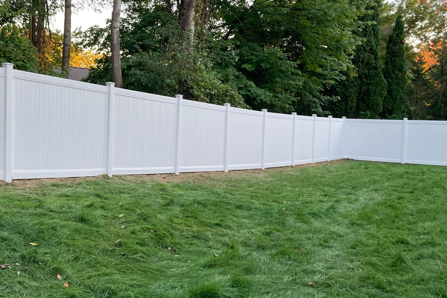 White vinyl privacy fence enclosing a residential backyard in West Michigan