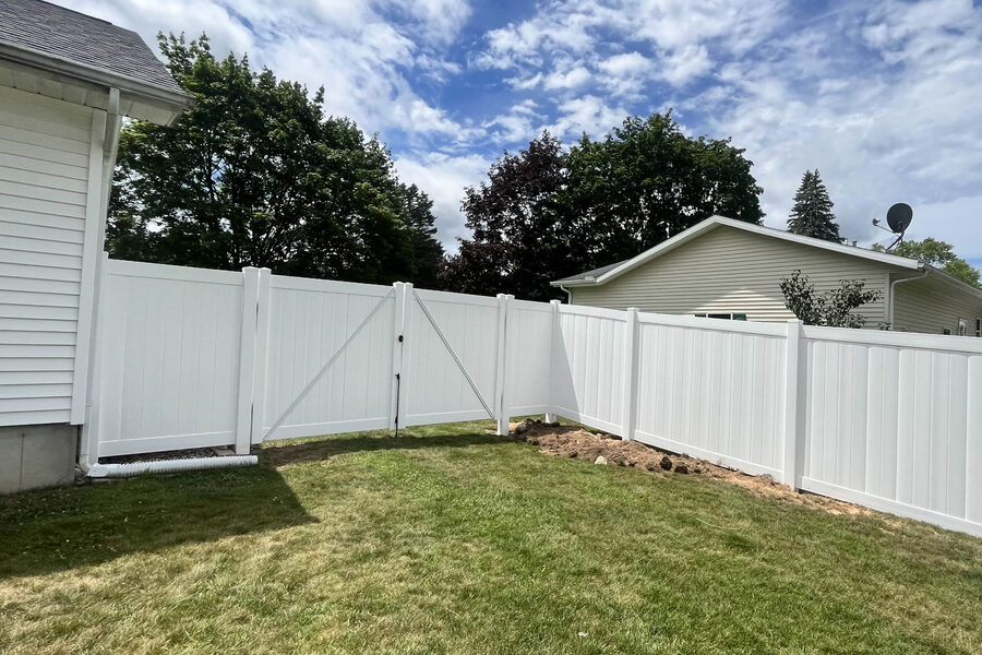 Vinyl privacy fence along a residential property in West Michigan